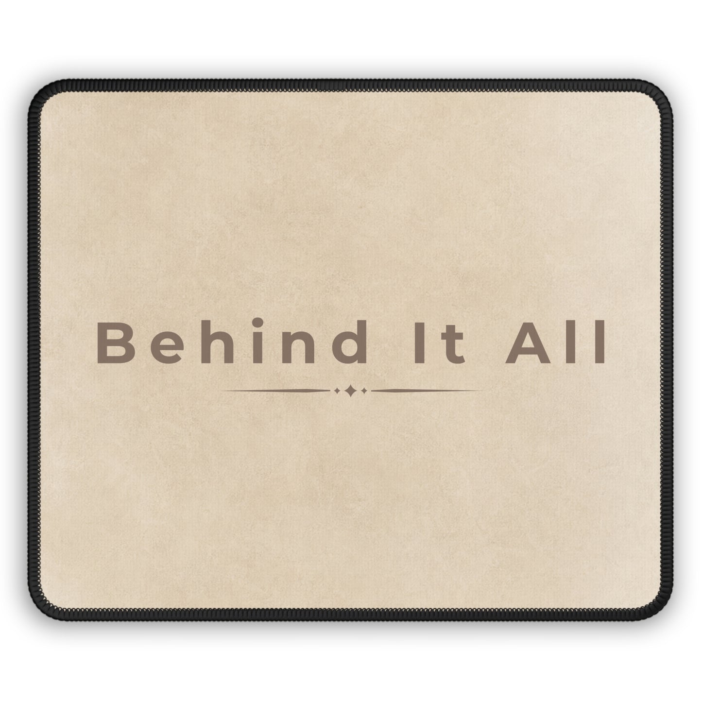 Beige mouse pad with 'Behind It All' text on a white background