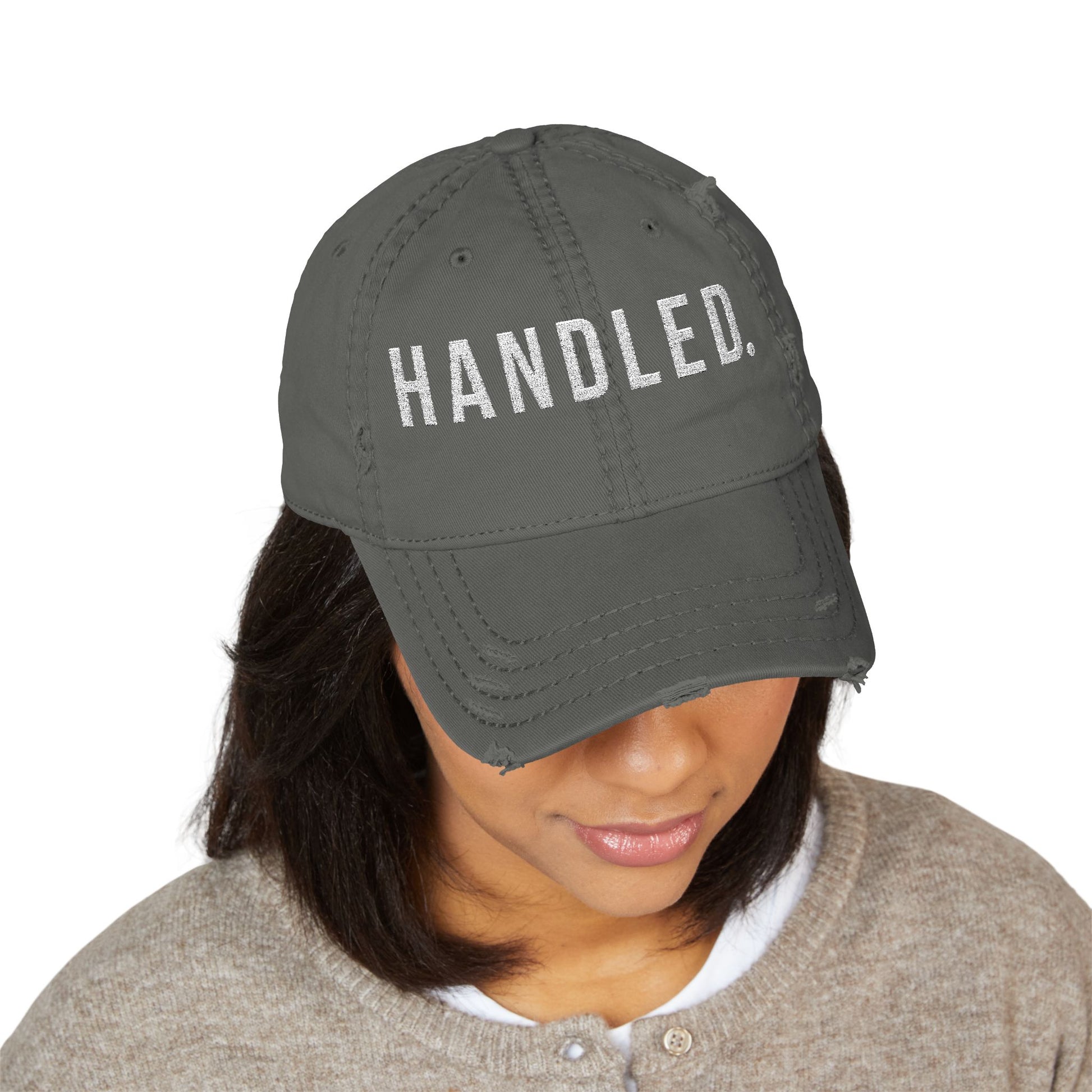 Person wearing a gray cap with  text on a white background