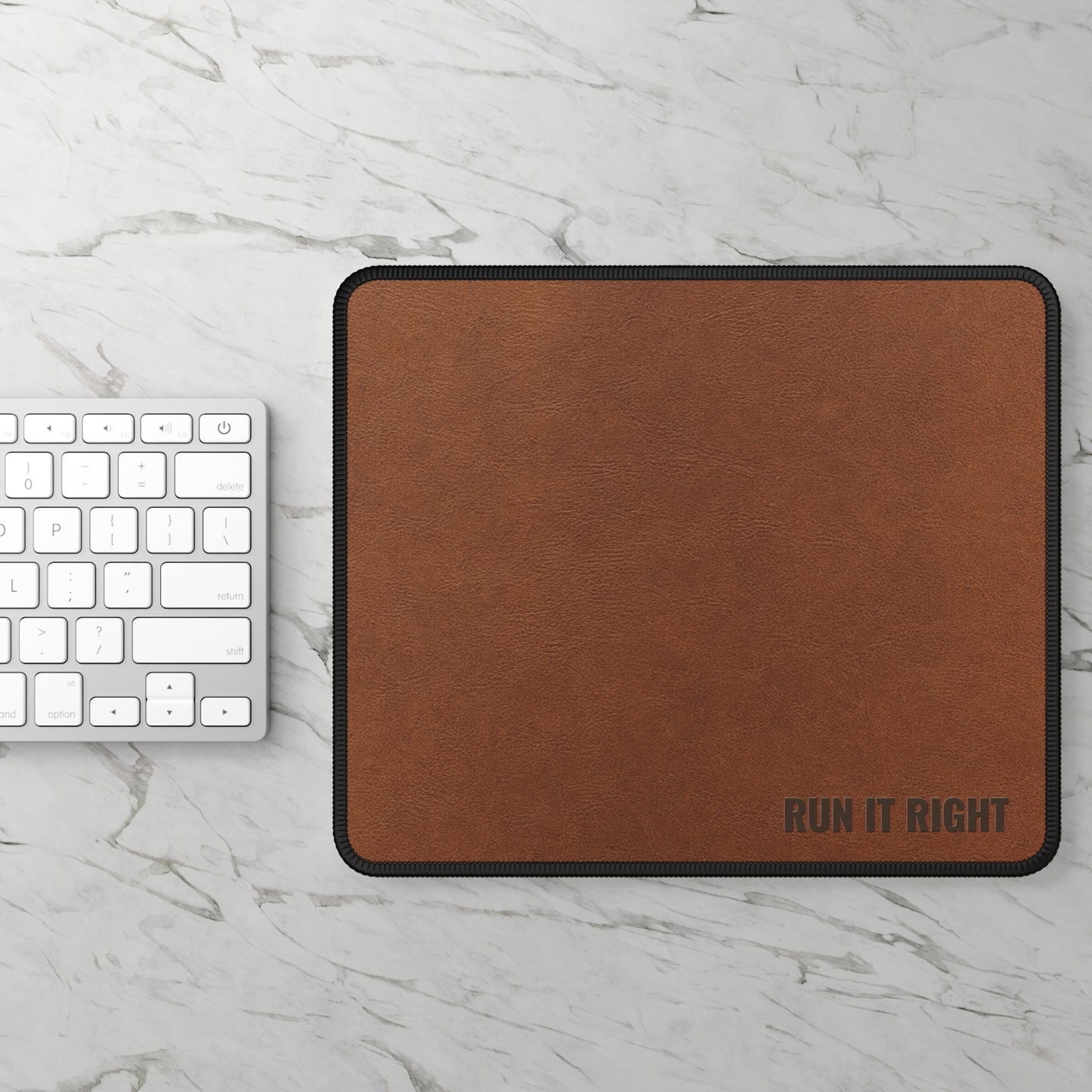 Brown mouse pad with 'RUN IT RIGHT' text on a marble surface with a keyboard.