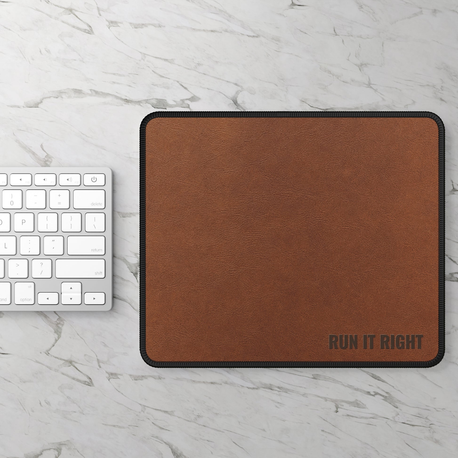Brown mouse pad with 'RUN IT RIGHT' text on a marble surface with a keyboard.