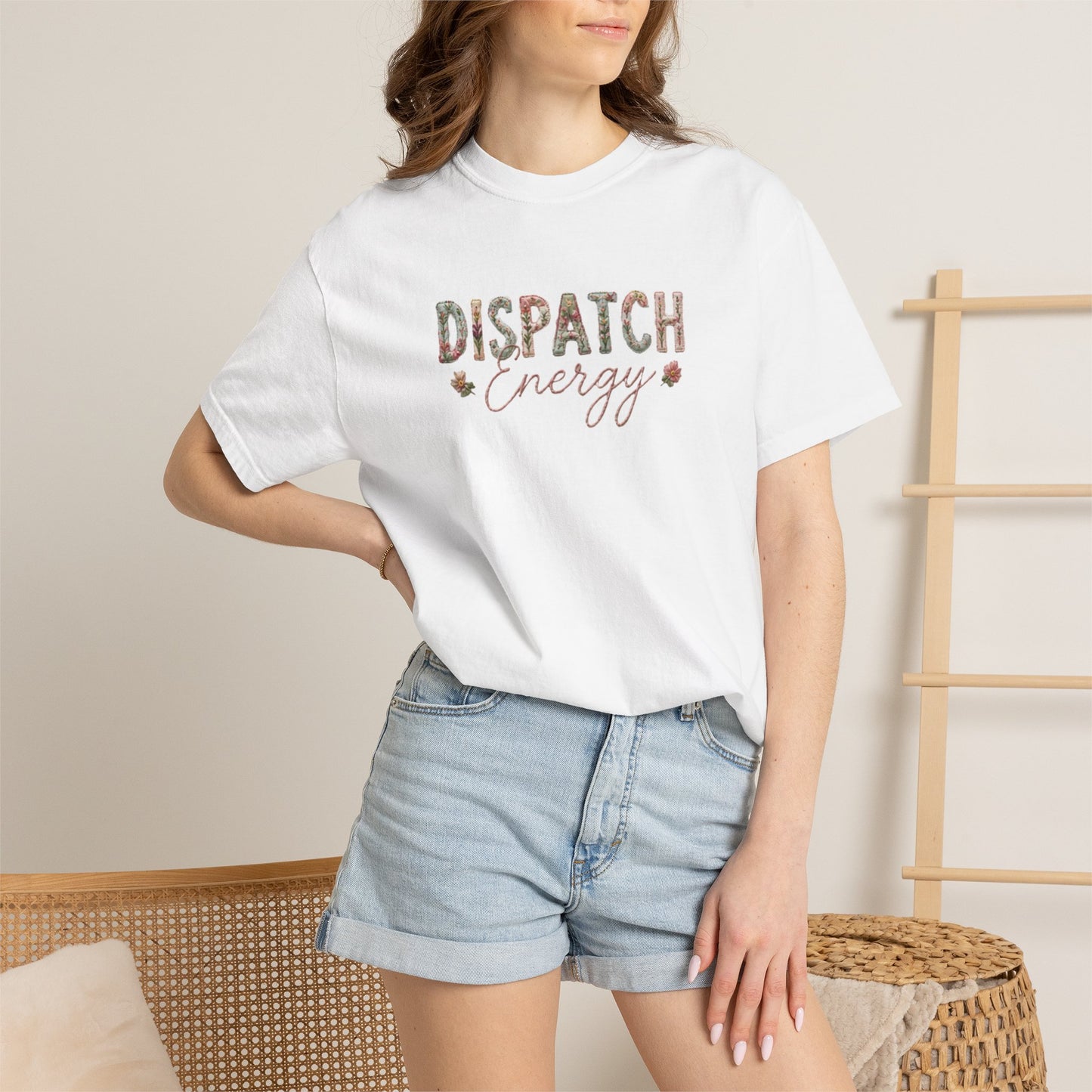 Person wearing a white t-shirt with 'DISPATCH ENERGY' text and denim shorts indoors.