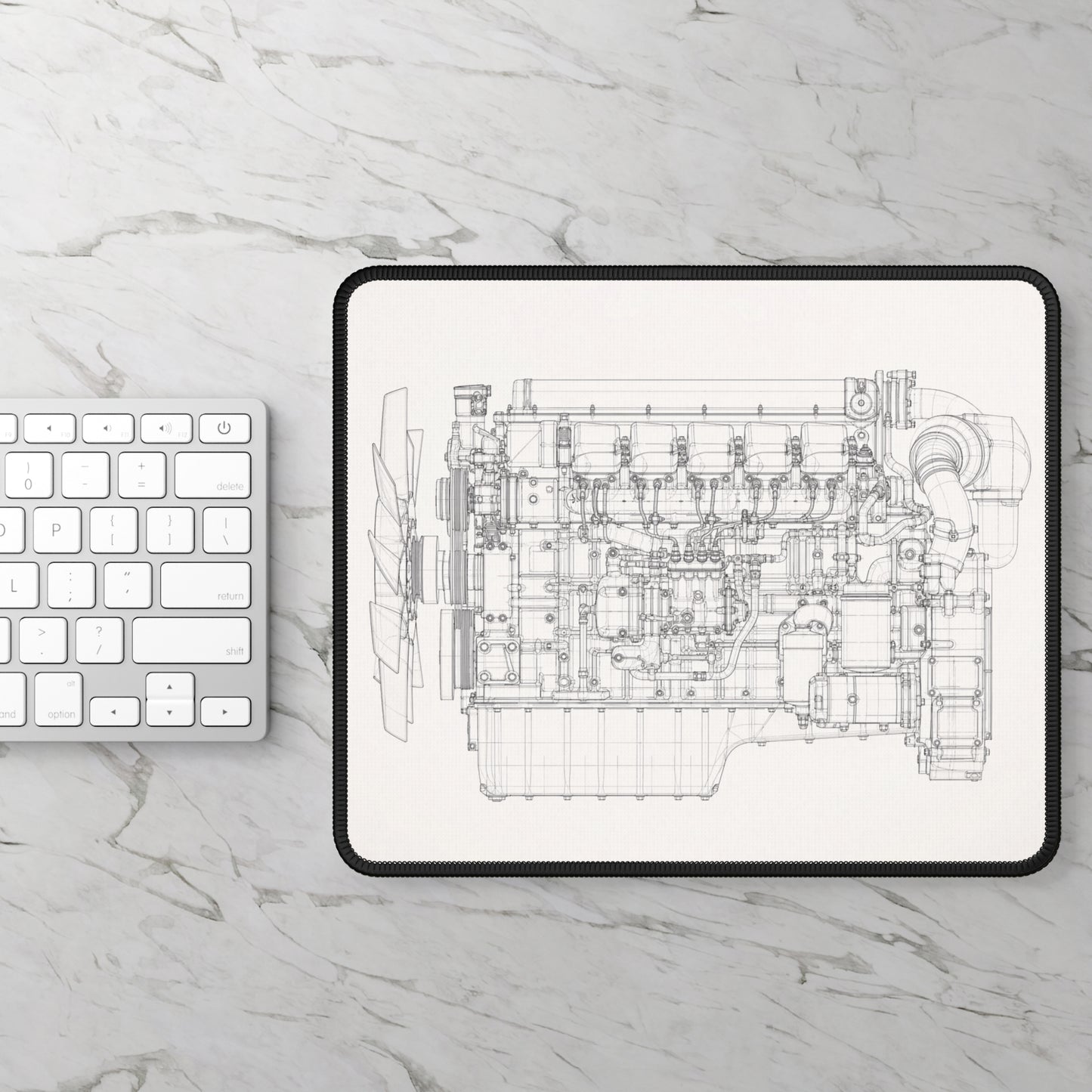 Engine blueprint on a tablet with a keyboard on a marble surface