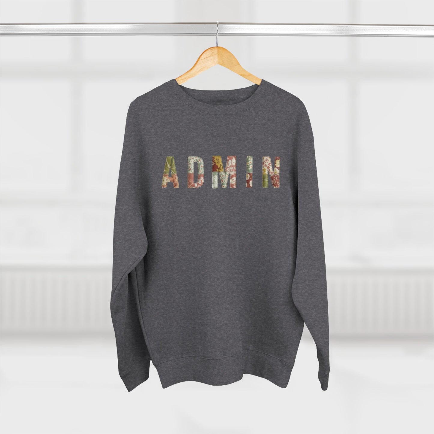 Gray sweatshirt with 'Admin' printed on it, hanging on a wooden hanger against a white background.