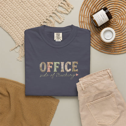 Navy blue t-shirt with 'OFFICE side of trucking' text on a neutral surface with accessories.