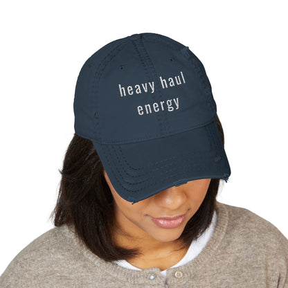 Person wearing a navy blue cap with a small embroidered patch on a white background