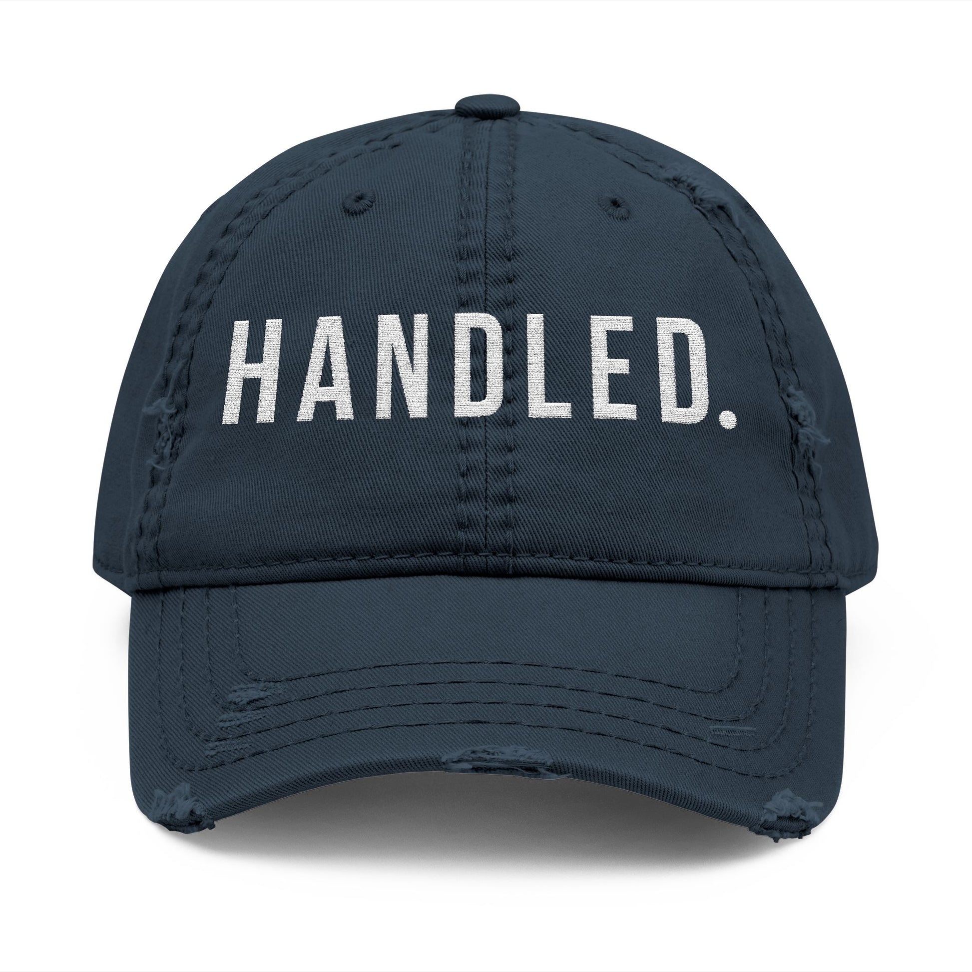 Navy blue cap with 'HANDLED.' text on a white background