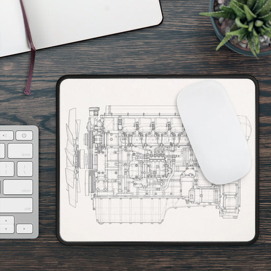 Engine diagram on a mouse pad with a keyboard and plant in the background