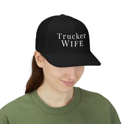 Person wearing a black cap with 'Trucker Wife' text on a white background