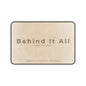 Beige mat with 'Behind It All' text on a white background