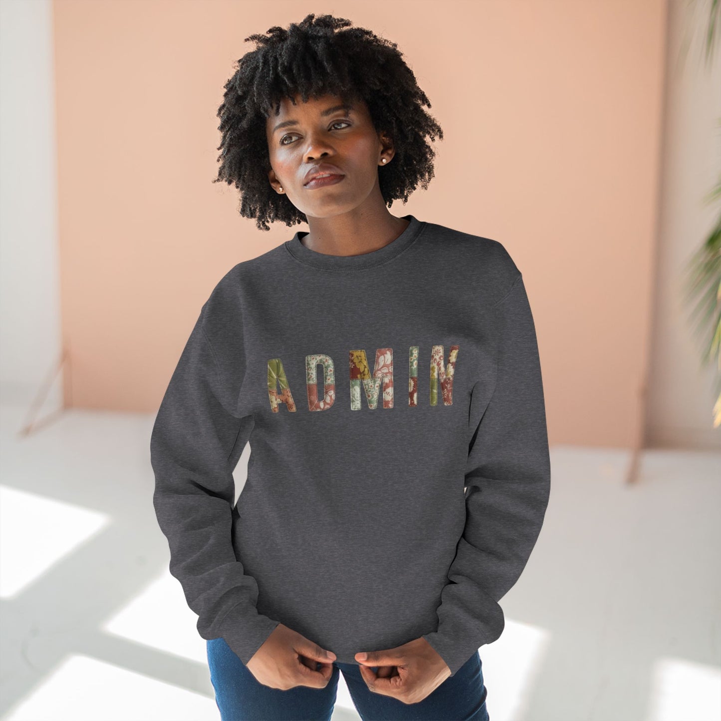 Person wearing a dark gray sweatshirt with 'ADMIN' printed in colorful letters against a light background.