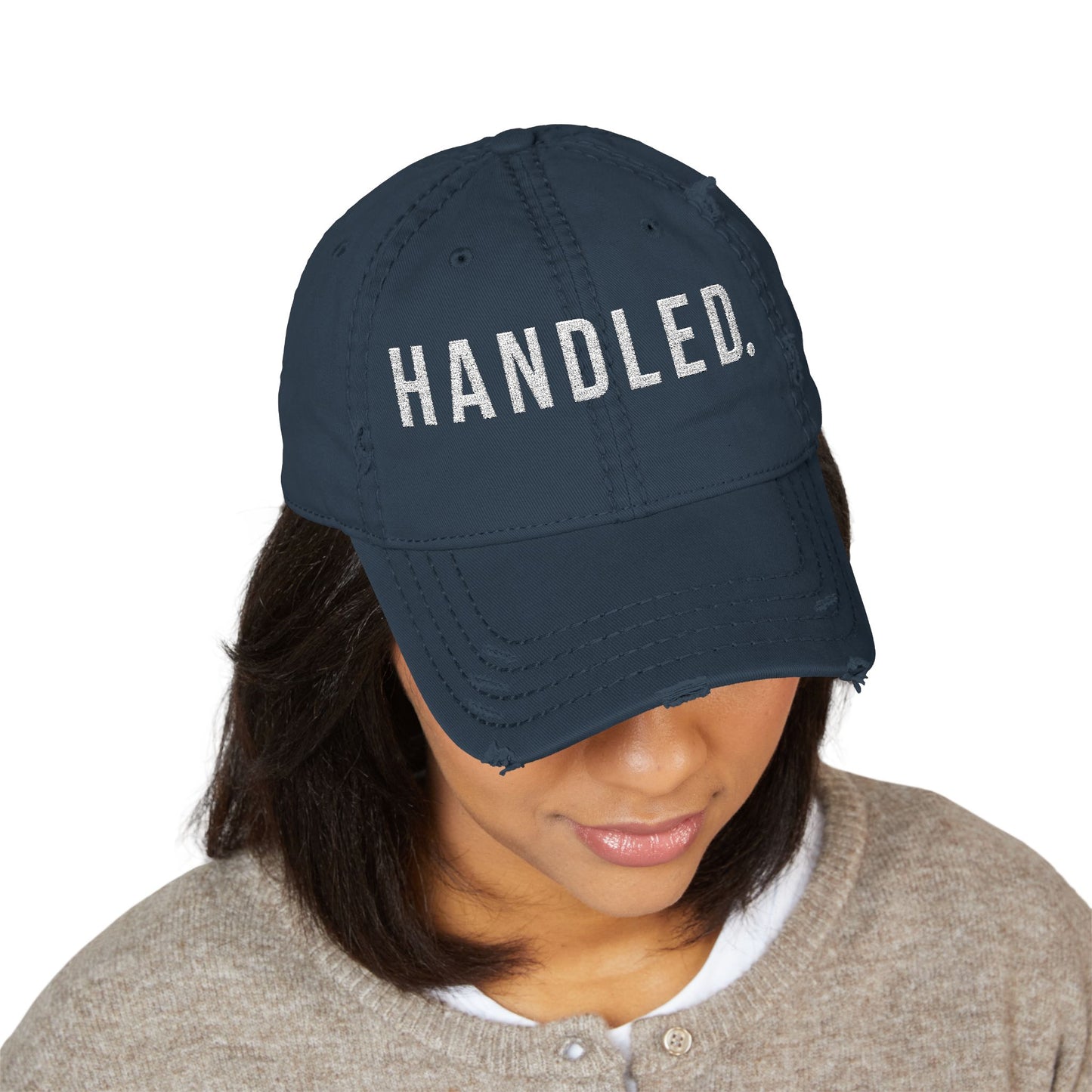 Navy blue cap with white text and logo worn by a person on a white background