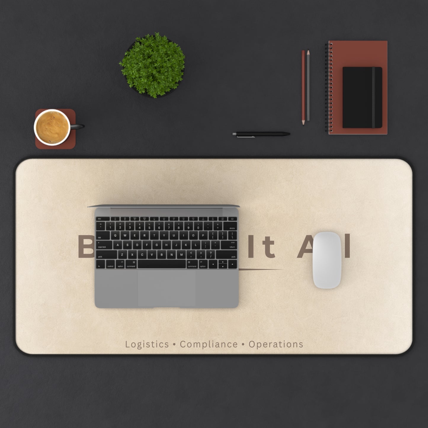 Desk setup with a laptop, mouse, and stationery on a large desk mat with text.