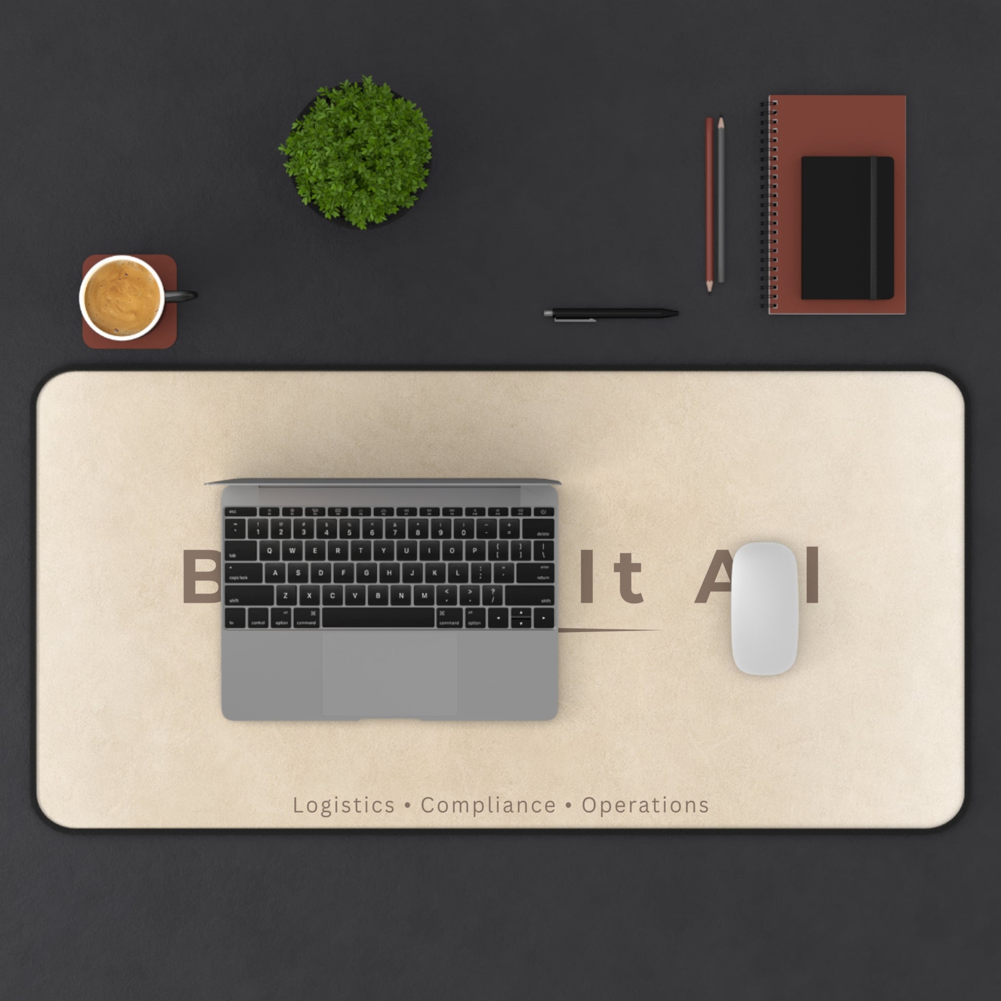 Desk setup with a laptop, mouse, and stationery on a large desk mat with text.
