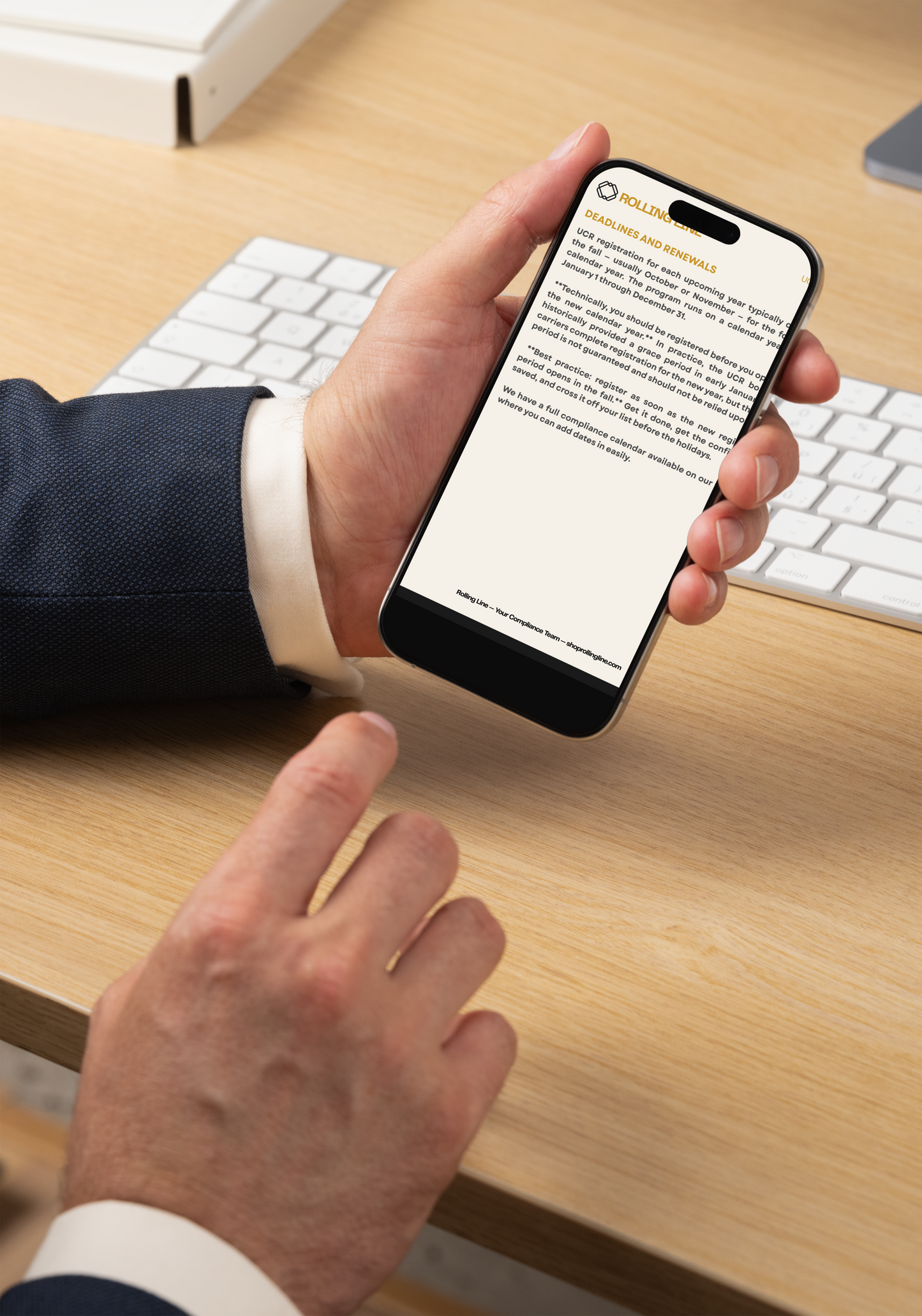 Person holding a smartphone with a document on a desk with a keyboard