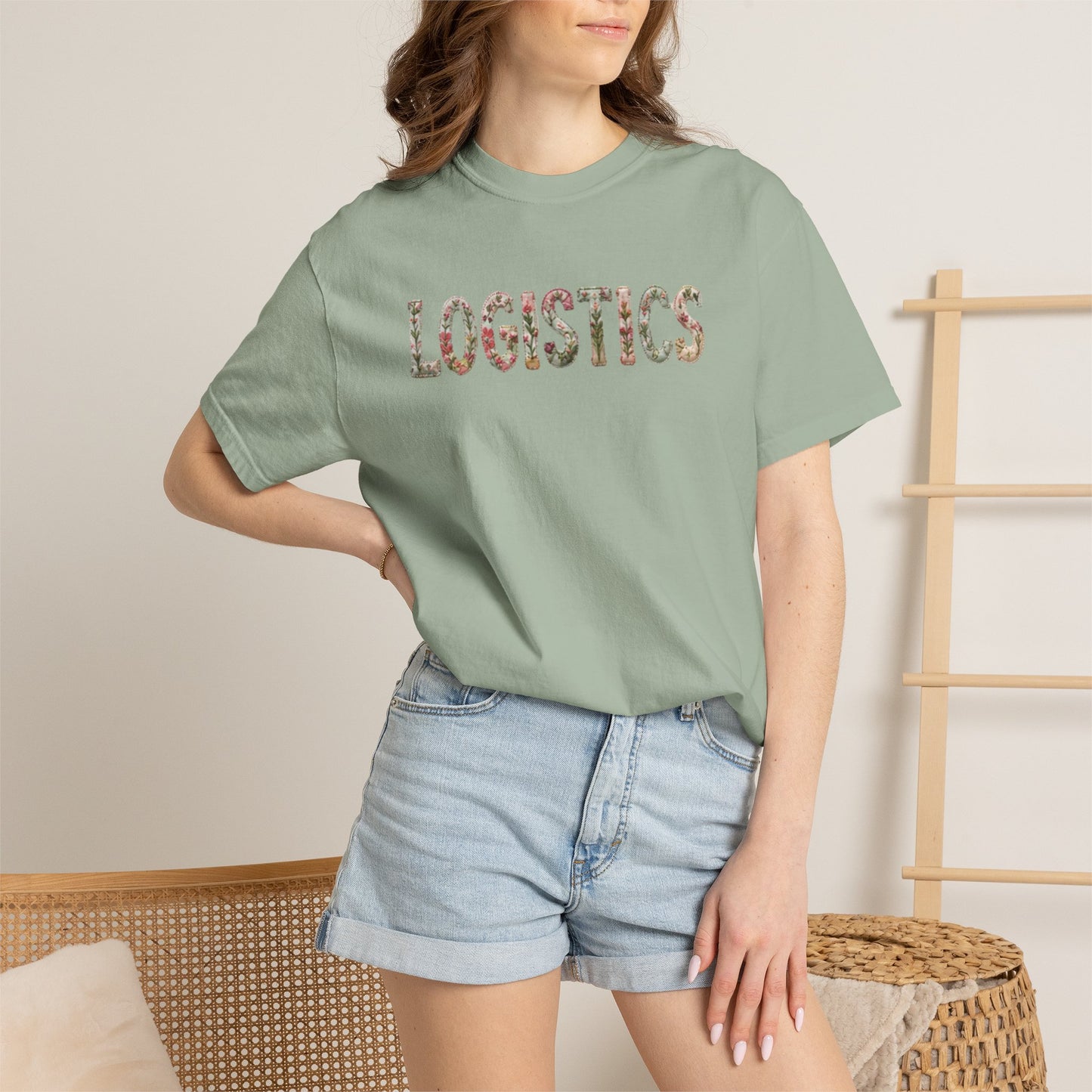 Person wearing a green t-shirt with a logo and denim shorts indoors.