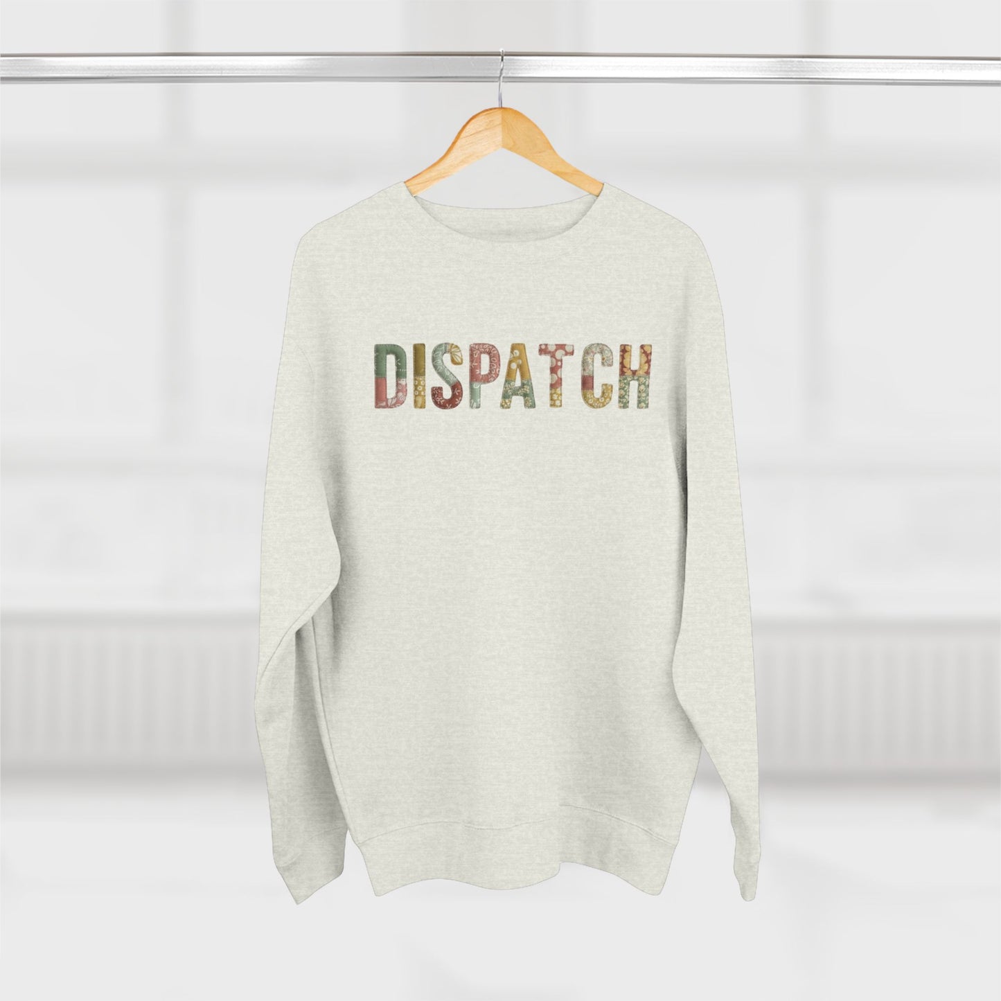 White sweater with 'DISPATCH' text on a hanger against a white background