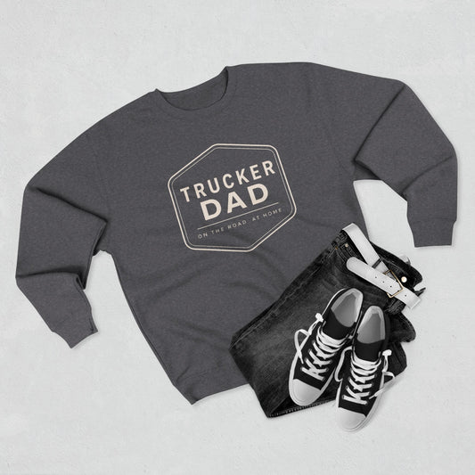 Gray sweatshirt with 'trucker dad' design, black jeans, and black sneakers on a light gray background