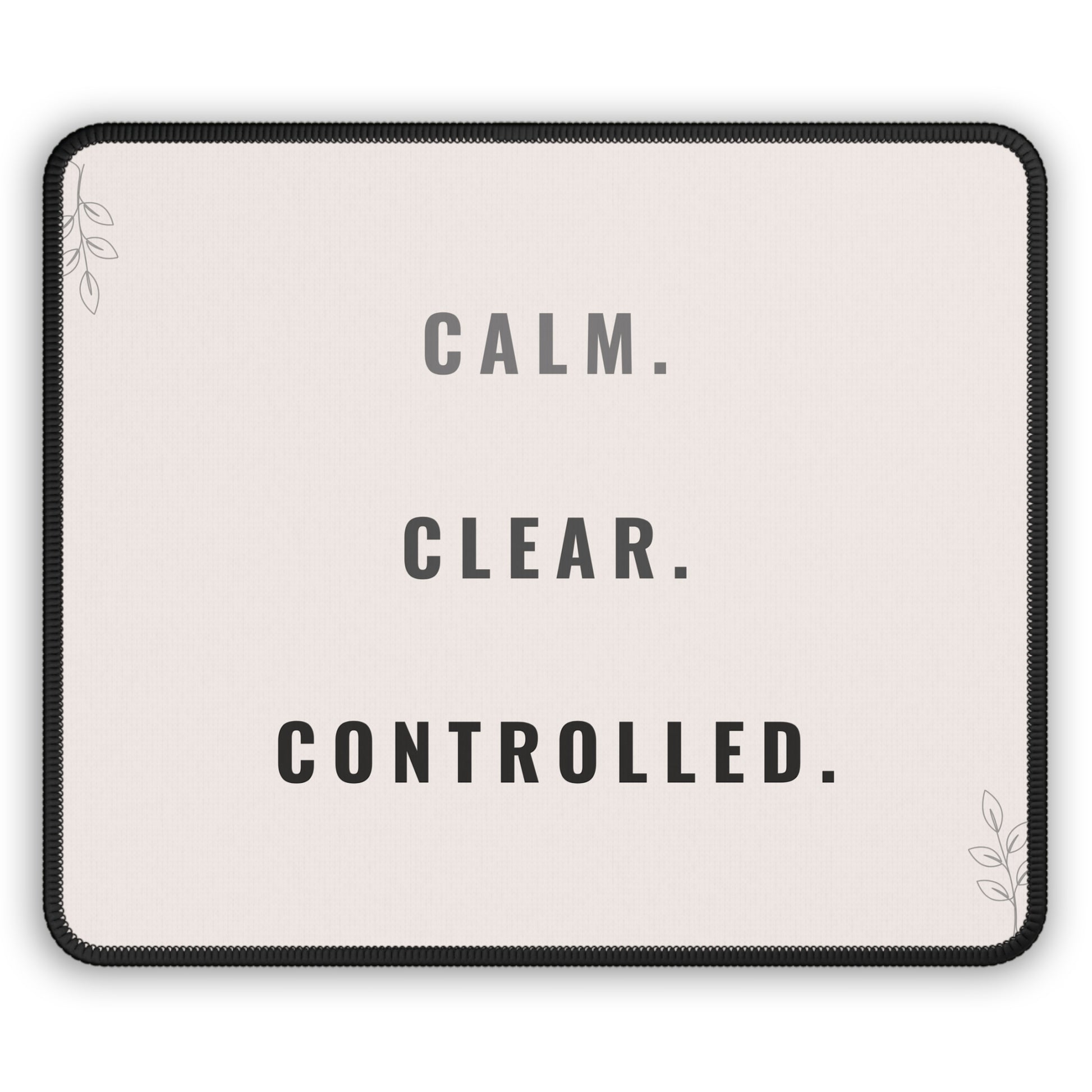Mouse pad with motivational text 'CALM. CLEAR. CONTROLLED.' on a light background