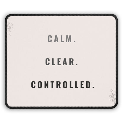 Mouse pad with motivational text 'CALM. CLEAR. CONTROLLED.' on a light background