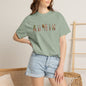 Person wearing a green t-shirt with a logo and denim shorts indoors.