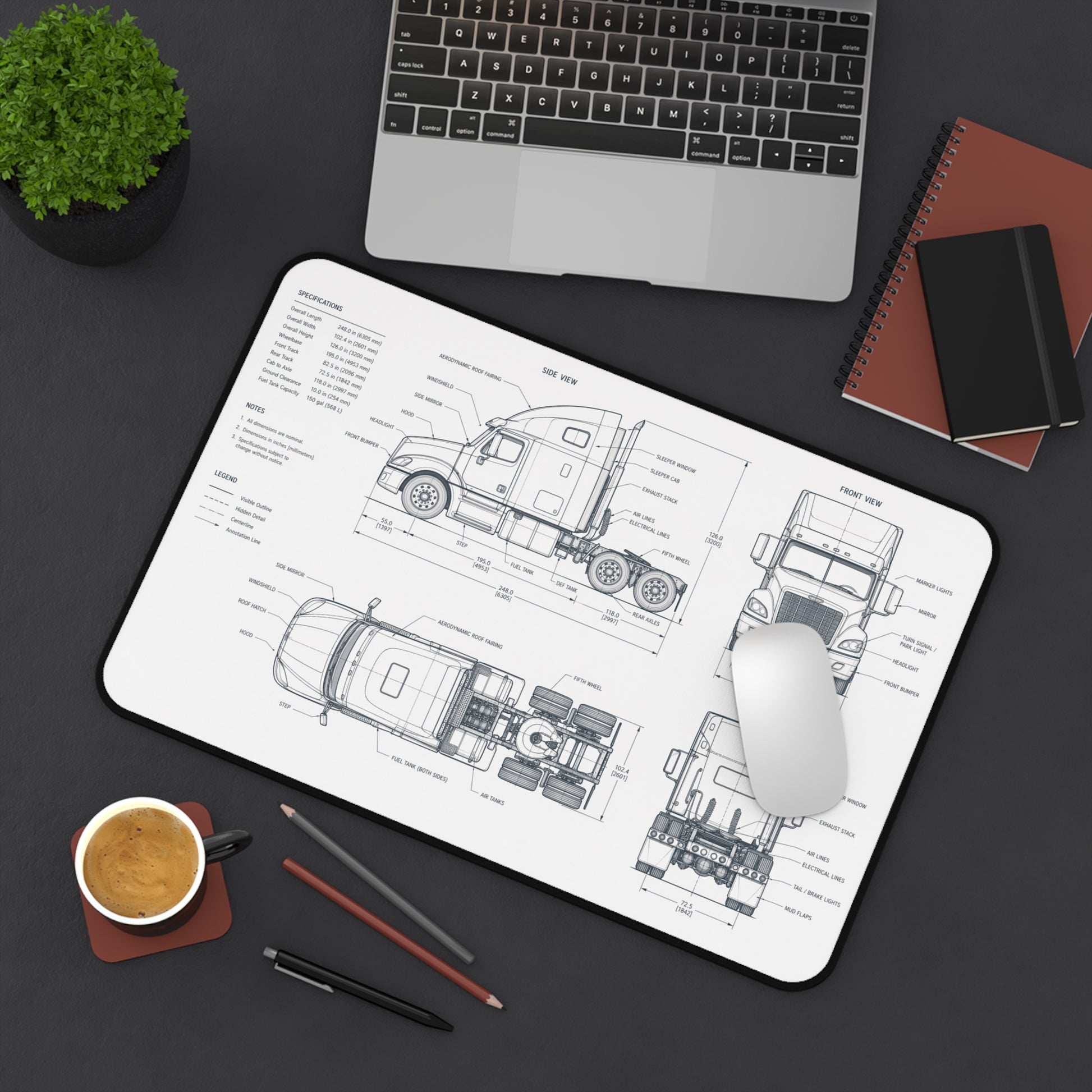 Desk setup with a mouse pad featuring technical drawings, laptop, notebook, and coffee cup.
