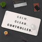 Desk setup with a mouse pad featuring 'Calm. Clear. Controlled.' text, laptop, phone, and coffee cup.