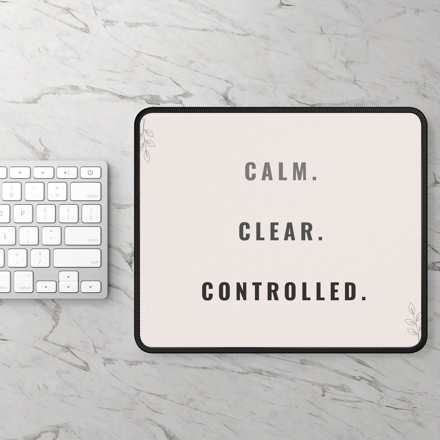 Tablet with 'CALM. CLEAR. CONTROLLED.' text on a marble surface with keyboard