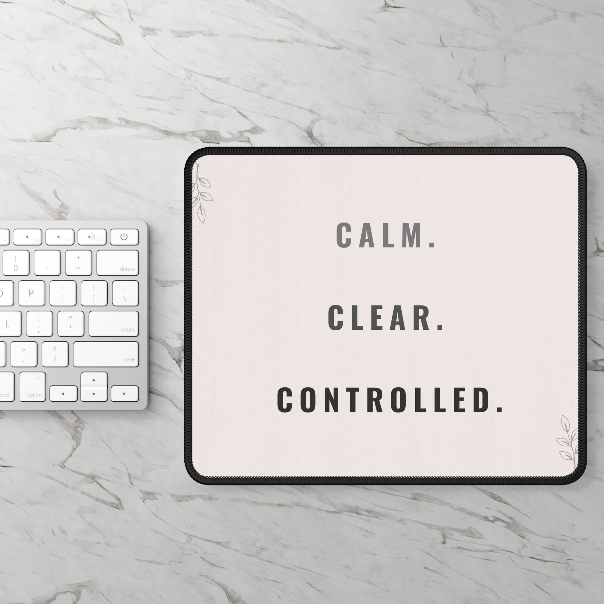 Tablet with 'CALM. CLEAR. CONTROLLED.' text on a marble surface with keyboard