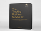 Black binder titled 'The Trucking Business Survival Kit' with gold text on a white background