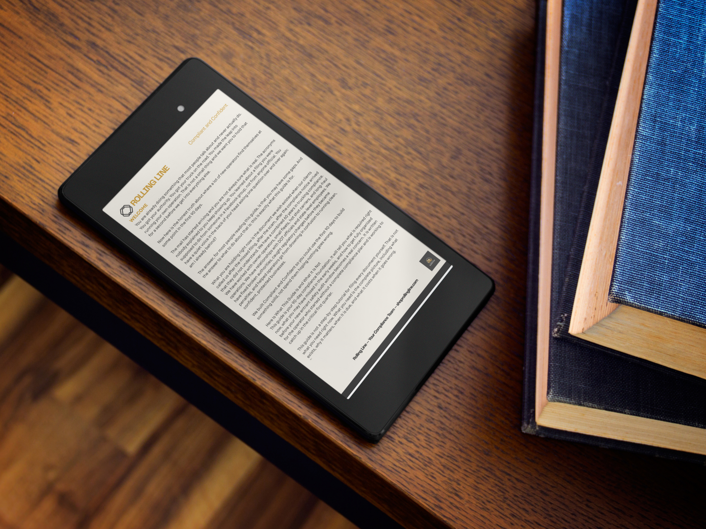 E-reader device on a wooden surface with books in the background