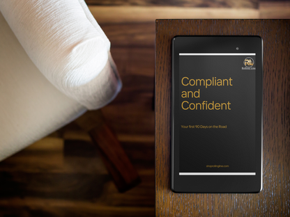 Black book titled 'Compliant and Confident' on a wooden surface with a blurred background